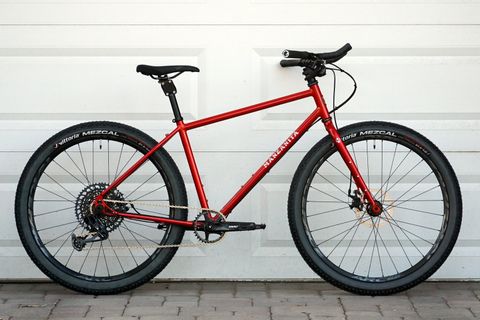 Red steel bikepacking bike with steel fork